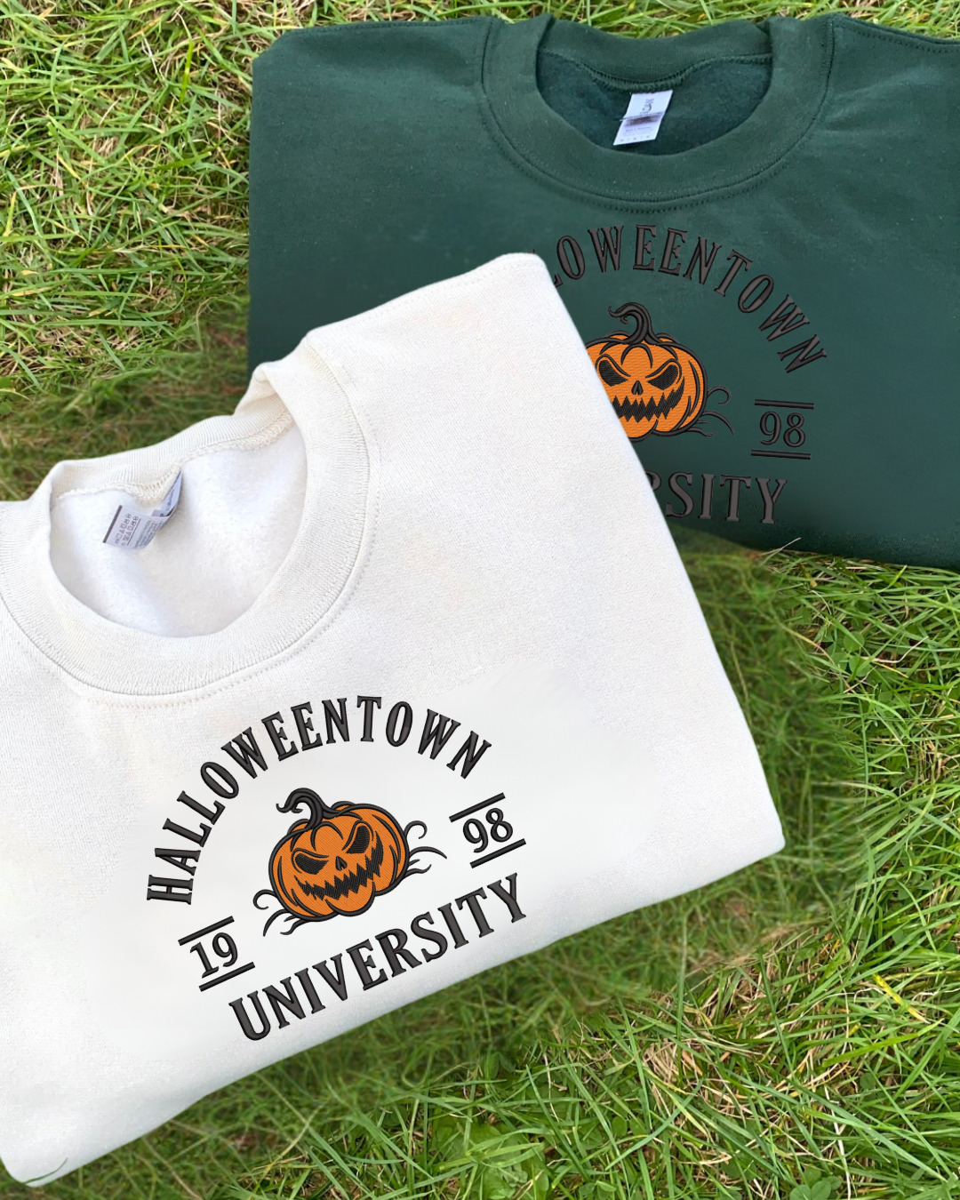Two sweatshirts with 'Halloweentown University' embroidery design on grass